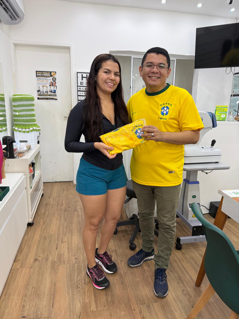 Cliente recebendo brinde na Óptica Visualize